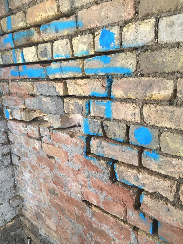 professionals using masonry stitching to repair cracks in brick wall